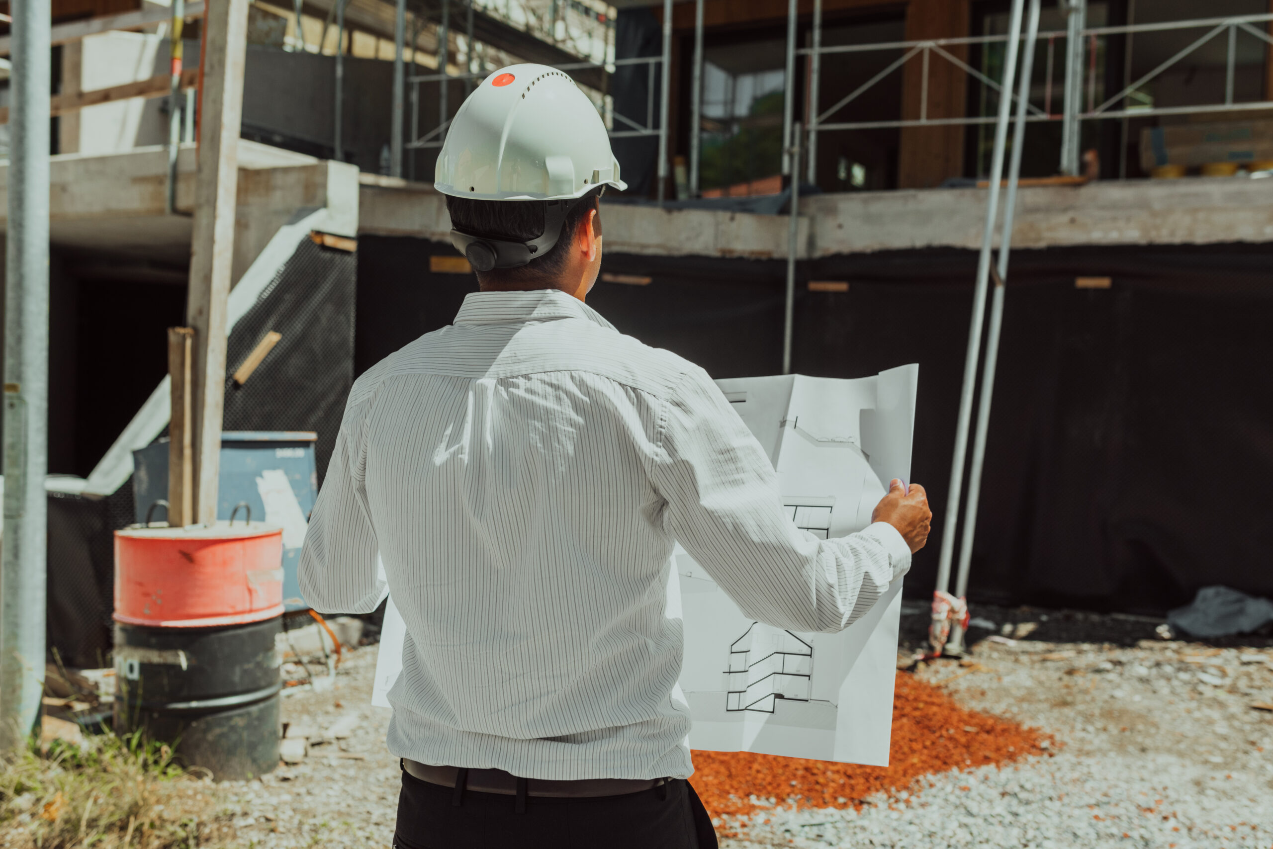 Home a architect looking at plan and thinking about working on big project. building in construction process interior.